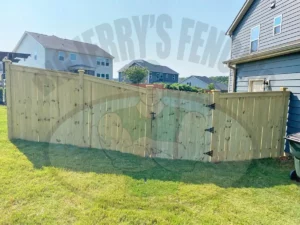 The Cannonball custom wood fence, featuring a contemporary design with cap and trim, showcases visible posts from both sides, offering a stylish and modern statement piece ideal for homes requiring an aesthetic and high-visibility yard boundary with a straight gate.