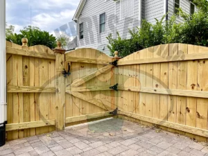 Hill wooden privacy fence with an elegant arch top design, offering a natural wood look and smooth transitions for yards with slopes and grade shifts, enhancing the aesthetic appeal and privacy of residential outdoor spaces.