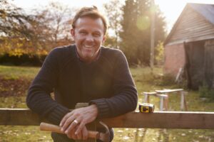 Portrait Of Mature Man Repairing Garden Fence