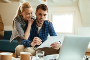 Smiling woman and her husband going through their home finances.