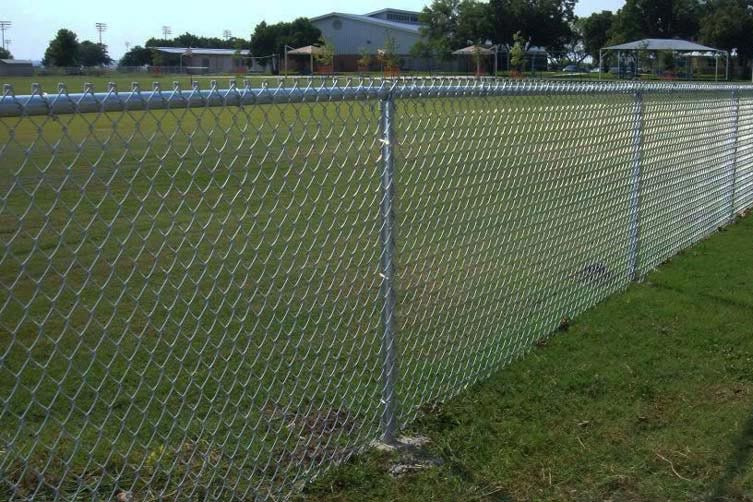 A standard chain link fence by a sports field