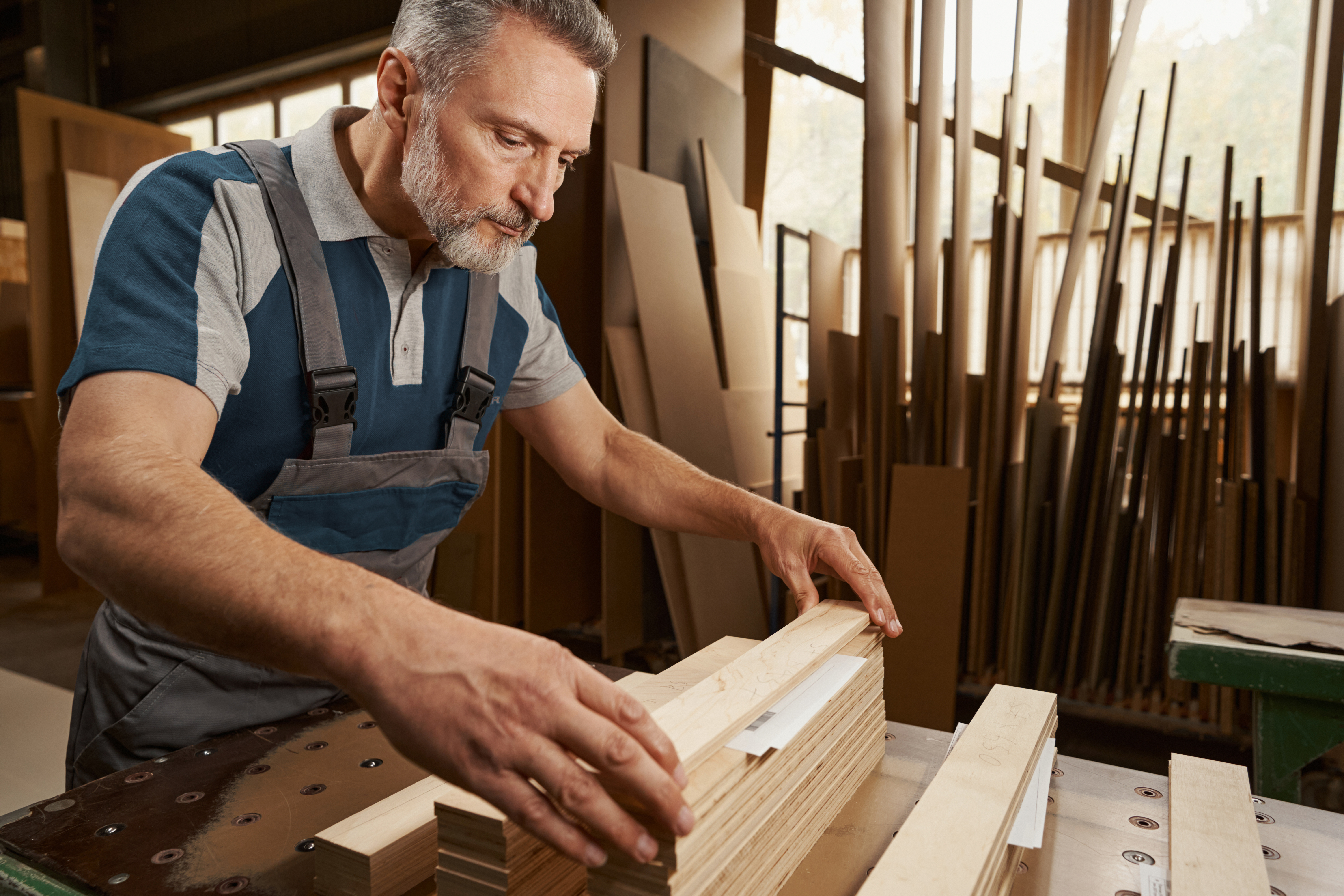 Concentrated bearded male person taking wooden timber
