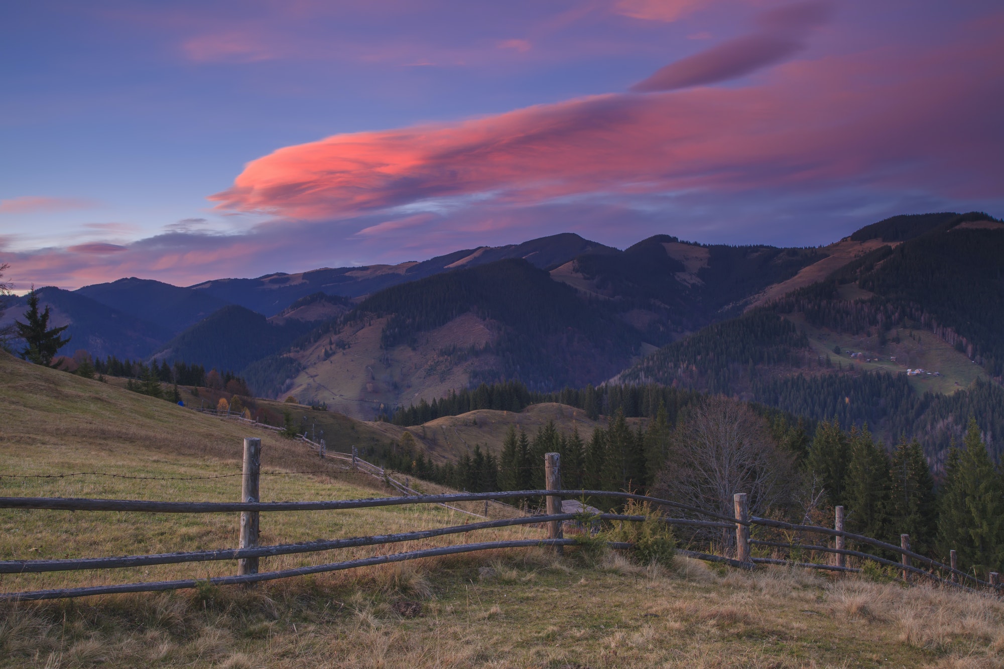 Beautiful sunset in the mountains on a slope with a fence