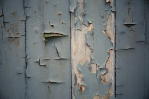 A worn and weathered texture background of flaked blue paint and rotting wood