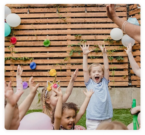 Kid's party in front of a wooden fence